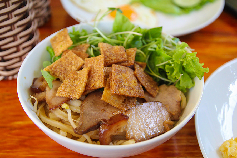 Hoi An's regional Vietnamese dish made with noodles, pork, and local greens with Man Nguyen Private Vietnam Tour Packages